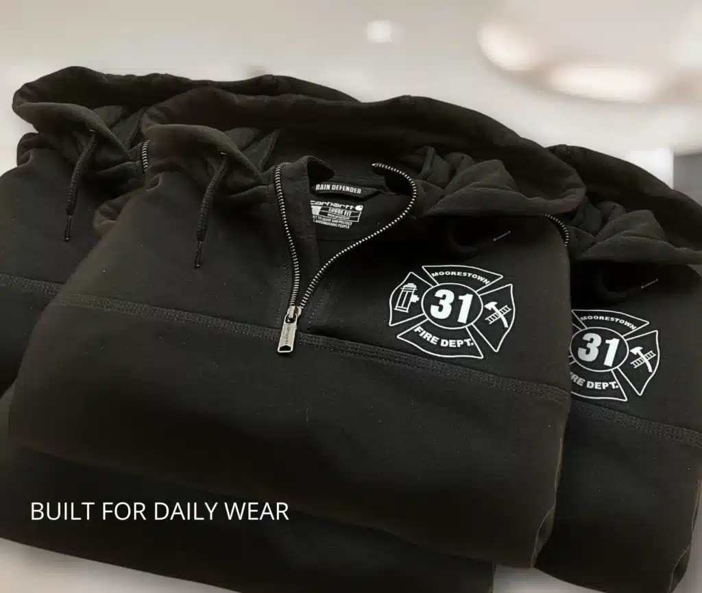 Custom fire department apparel featuring Station 31 logo on black quarter-zip hoodie.