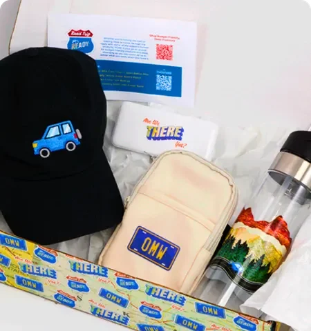 Custom promotional gift set with embroidered cap, pouch, water bottle, and branded inserts arranged in a presentation box